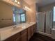Well-lit bathroom features double sinks, modern fixtures, and a glass-enclosed shower at 7572 Coyote Cave Ave, Las Vegas, NV 89113