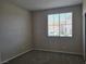 Neutral carpeted bedroom featuring a bright window and view of a neighborhood at 7572 Coyote Cave Ave, Las Vegas, NV 89113