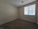 This carpeted bedroom has neutral walls and a bright window with privacy blinds at 7572 Coyote Cave Ave, Las Vegas, NV 89113
