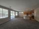 Expansive living room with neutral carpet flooring and an open layout to the kitchen at 7572 Coyote Cave Ave, Las Vegas, NV 89113