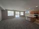 Open-concept living room features neutral carpet, natural light, and an adjacent kitchen at 7572 Coyote Cave Ave, Las Vegas, NV 89113