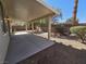 Spacious covered patio in a backyard with rock ground cover and privacy wall at 7572 Coyote Cave Ave, Las Vegas, NV 89113
