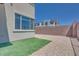 Backyard with stone patio, synthetic grass, rock landscaping, and block wall at 860 Echelon St, Las Vegas, NV 89138