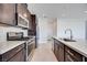 Modern kitchen features stainless steel appliances, dark wood cabinets, and a large island with sink at 860 Echelon St, Las Vegas, NV 89138