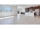 Open-concept living space with tile floors, large windows, and a kitchen in the background at 860 Echelon St, Las Vegas, NV 89138