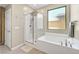 Luxurious bathroom featuring a glass-enclosed shower and a soaking tub beneath a window at 949 Bayberry Ridge St, Henderson, NV 89052
