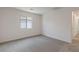 Bright, minimalist bedroom with neutral carpeting and a window offering natural light at 1708 Desert Path Ave, North Las Vegas, NV 89032