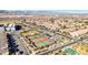 An aerial view of community tennis courts, landscaping, housing and mountains in the distance at 2120 Waterlily View St, Henderson, NV 89044