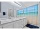 Bright bathroom with double sinks, a large mirror, and a shower with a beach themed shower curtain at 2419 Country Orchard St, North Las Vegas, NV 89030