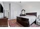 Comfortable bedroom featuring a dark wood bed, an ornate dresser, and a cozy rug at 2419 Country Orchard St, North Las Vegas, NV 89030