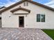 View of a home's backyard with paver flooring, a small grass area, window and door at 4117 Midnight Crest Ave, North Las Vegas, NV 89031