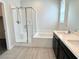 Bright bathroom featuring a dual vanity, a tub, and a glass-enclosed tiled shower at 4117 Midnight Crest Ave, North Las Vegas, NV 89031