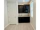 A modern kitchenette featuring sleek dark cabinets, granite countertops, and tile flooring at 4117 Midnight Crest Ave, North Las Vegas, NV 89031