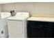 Bright laundry room with white appliances and ample counter space with dark cabinets at 4117 Midnight Crest Ave, North Las Vegas, NV 89031