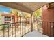 Balcony view of community buildings, mature trees, and walking paths beyond wrought iron railing at 5576 W Rochelle Ave # 9C, Las Vegas, NV 89103