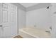 Bathroom featuring a large soaking tub with tile surround, white door, and a shower head at 5576 W Rochelle Ave # 9C, Las Vegas, NV 89103