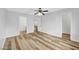 Light-filled bedroom with wood-look floors and a ceiling fan, showcasing doorways to an ensuite and closet at 5576 W Rochelle Ave # 9C, Las Vegas, NV 89103