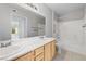 Bright bathroom with double sinks, wooden cabinets, and a shower-tub combo at 5710 E Tropicana Ave # 1184, Las Vegas, NV 89122