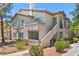 Beige two-story condo building with a private balcony and desert landscaping at 5710 E Tropicana Ave # 1184, Las Vegas, NV 89122