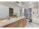 Well-lit bathroom featuring double sinks, a bathtub with shower, and a decorative shower curtain at 6057 Leaping Foal St, North Las Vegas, NV 89081