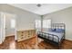 Cozy bedroom with hardwood floors, a metal bed frame, and bright windows with plantation shutters at 6057 Leaping Foal St, North Las Vegas, NV 89081
