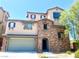 Inviting two-story home with a stone facade and well-manicured lawn, and attached two-car garage at 10450 Badger Ravine St, Las Vegas, NV 89178