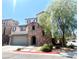 Attractive two-story home with a stone facade, and a tree shading the front, creating curb appeal at 10450 Badger Ravine St, Las Vegas, NV 89178
