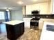 Modern kitchen featuring an island, stainless steel appliances, and stone countertops at 10450 Badger Ravine St, Las Vegas, NV 89178