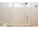 All-white bathtub and shower space with tiled walls and a small window for natural light at 1161 Gecko Rd, Henderson, NV 89002