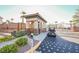 Community entrance with a gate house, golf cart, and well-maintained landscaping at 1161 Gecko Rd, Henderson, NV 89002