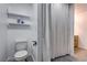 Bathroom featuring toilet, storage shelves, and shower with curtain at 3008 Saint George St # F, North Las Vegas, NV 89030