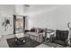 Bright living room featuring a large sofa, a black rug, and sliding glass doors to the patio at 3008 Saint George St # F, North Las Vegas, NV 89030