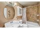 Cozy bathroom with neutral wall paint, round mirror and bathtub with tile surround at 5580 Lonesome Biker Ln, Las Vegas, NV 89113