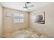 Neutral bedroom with tiled floors, ceiling fan, plantation shutters, and decorative wall art at 5580 Lonesome Biker Ln, Las Vegas, NV 89113