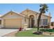 Charming single-story home featuring a desert landscaping, green grass and mature palm tree at 5580 Lonesome Biker Ln, Las Vegas, NV 89113