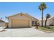 Charming single-story home featuring a two-car garage, desert landscaping and mature palm trees at 5580 Lonesome Biker Ln, Las Vegas, NV 89113