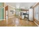 Open-concept living area with hardwood floors, shutters, white kitchen cabinetry, and stainless appliances at 5580 Lonesome Biker Ln, Las Vegas, NV 89113