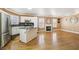 Open-concept living area with kitchen island, fireplace, hardwood floors, and stainless appliances at 5580 Lonesome Biker Ln, Las Vegas, NV 89113