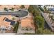 Aerial view of a residence with tile roof, mature trees, driveway and hardscape backyard at 9836 Russett Wood Cir, Las Vegas, NV 89117