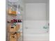 Well-organized bathroom with shelving unit next to soaking tub at 9836 Russett Wood Cir, Las Vegas, NV 89117
