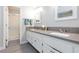 Bright bathroom featuring double sinks, granite countertops, and walk-in shower at 9836 Russett Wood Cir, Las Vegas, NV 89117