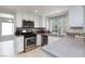 Modern kitchen with stainless steel appliances, gray countertops, and a large window overlooking the backyard at 9836 Russett Wood Cir, Las Vegas, NV 89117