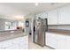 Bright kitchen featuring stainless steel refrigerator, white cabinets, and ample counter space at 9836 Russett Wood Cir, Las Vegas, NV 89117