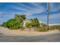 Single-story home with tiled roof surrounded by mature trees under a blue sky at 6990 W Richmar Ave, Las Vegas, NV 89178