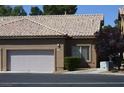 Tan stucco exterior with tile roof and two-car garage at 4727 Wild Draw Dr, North Las Vegas, NV 89031