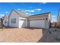 Attractive home features a brick driveway leading to a two-car garage under a partly cloudy, vibrant blue sky at 7132 Silver Palace St, Las Vegas, NV 89131