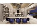 Elegant dining area with a large table, modern chairs, a statement chandelier, and a wine cellar nearby at 616 Scenic Rim Dr, Henderson, NV 89012
