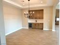 Elegant dining area with a built-in wet bar, chandelier and hardwood floors at 5569 Artex Ave, Las Vegas, NV 89139