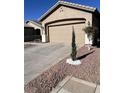 Tan house with a two-car garage and desert landscaping at 6072 Corbin Ave, Las Vegas, NV 89122