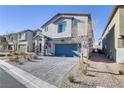 Two-story house with a gray facade, blue garage door, and landscaped front yard at 8351 Gold River Ct, Las Vegas, NV 89113